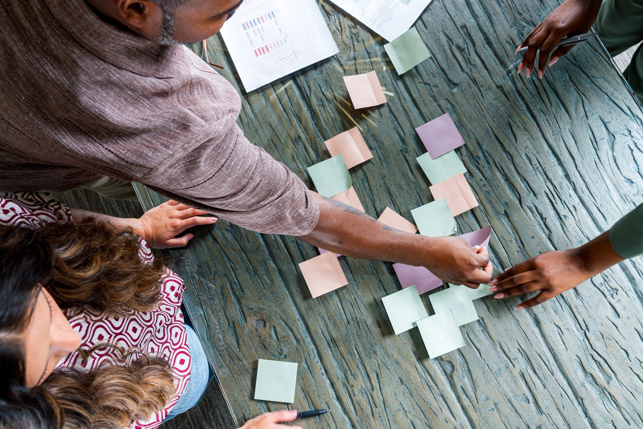 Team organizing ideas and responsibilities with notes